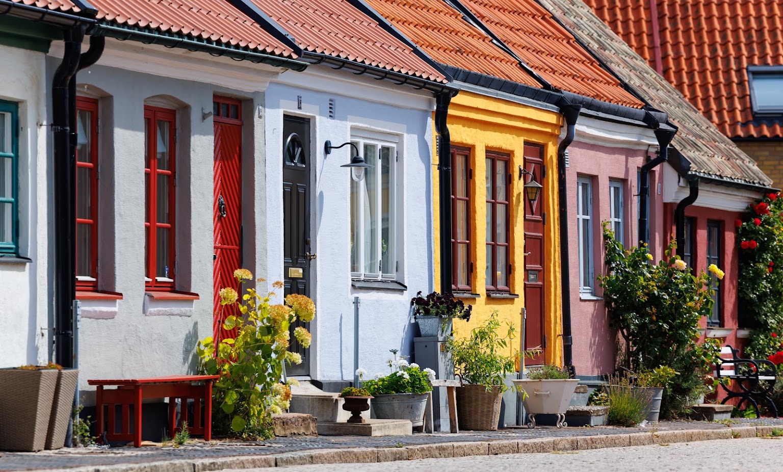 Färgglada småhus med blommor i Landskrona