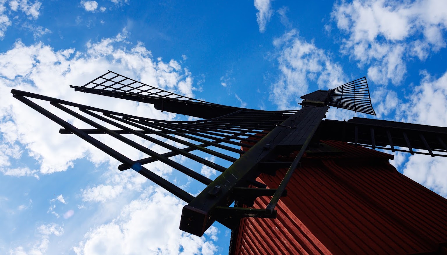 Väderkvarnens vingar mot blå himmel